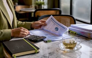 Hands organizing VAT accounting reports and calculator